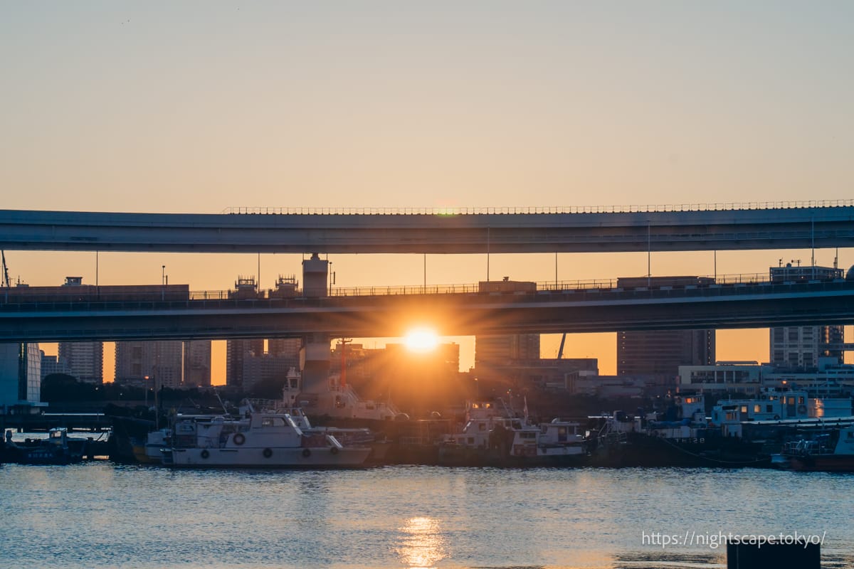 The rising sun in the centre of the loop bridge.