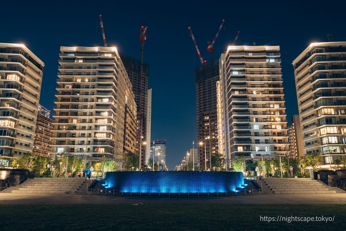 Harumi's towers and fountain pond illuminated in blue