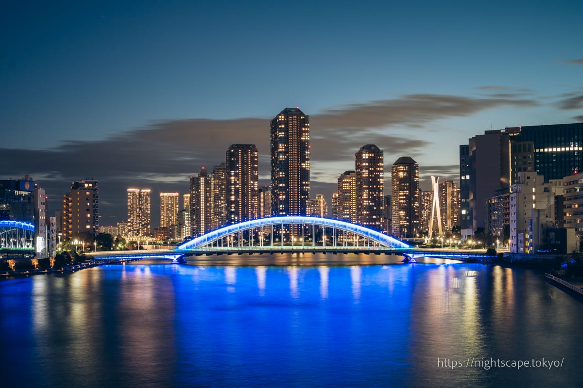 青く輝く永代橋と月島の高層ビル群の夜景