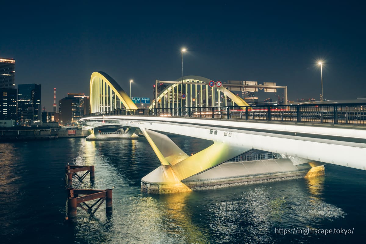 黄色にライトアップされる築地大橋
